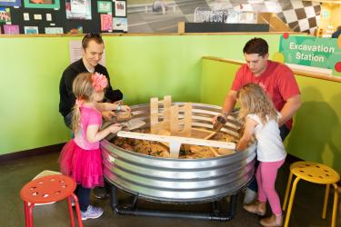 Families playing at the excavation station