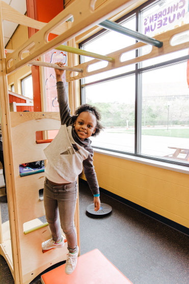 Child hanging from monkey bars